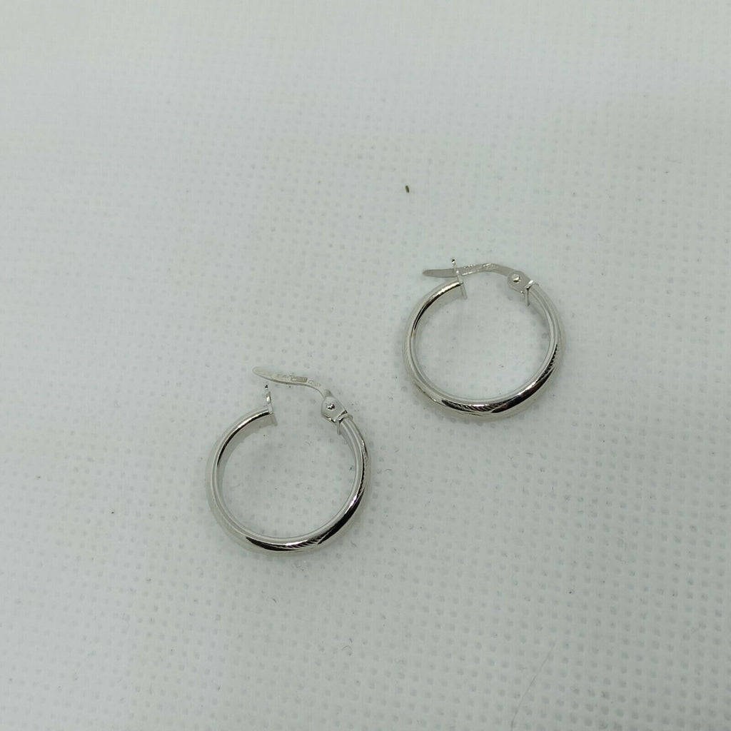 Orecchini a cerchi oro bianco 18 kt  con lavorazione a rilievo e incisioni.