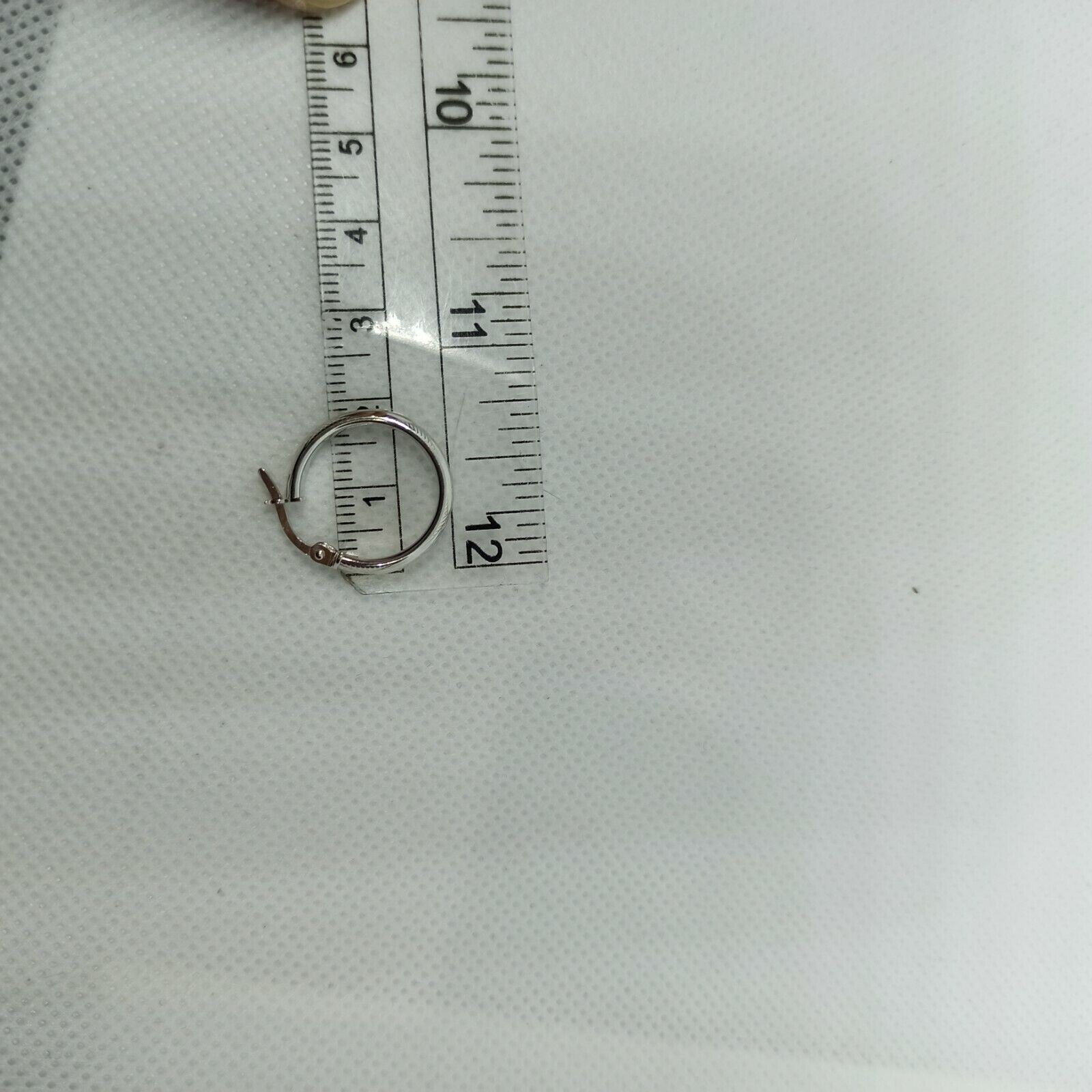 Orecchini a cerchi oro bianco 18 kt  con lavorazione a rilievo e incisioni.