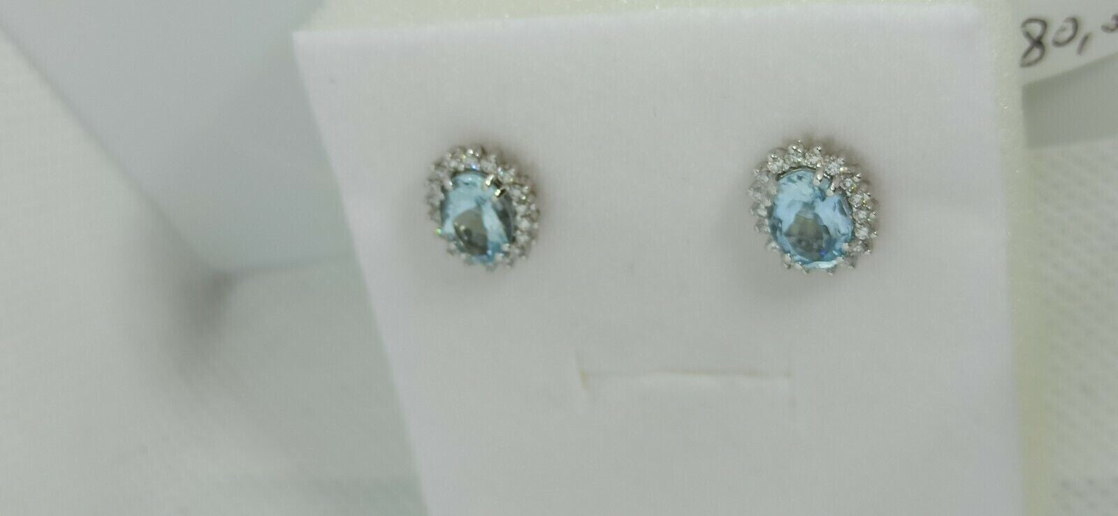 Orecchini in oro bianco 18 kt con acquamarina ovale contornata da diamanti .