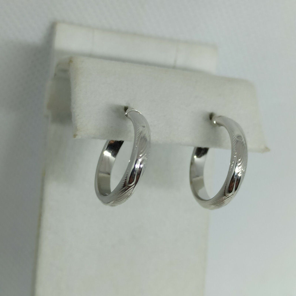 Orecchini a cerchi oro bianco 18 kt  con lavorazione a rilievo e incisioni.