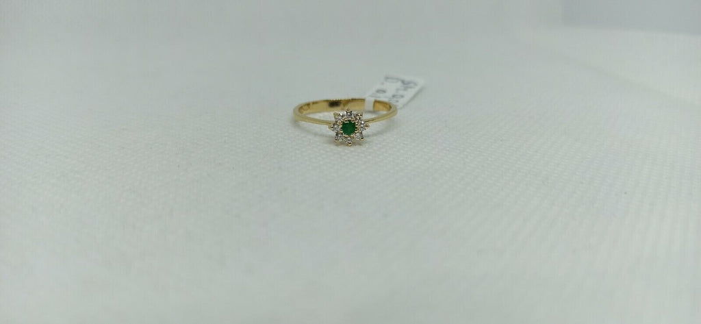 Anello in oro giallo 18 kt con smeraldo tondo e contorno di diamanti.