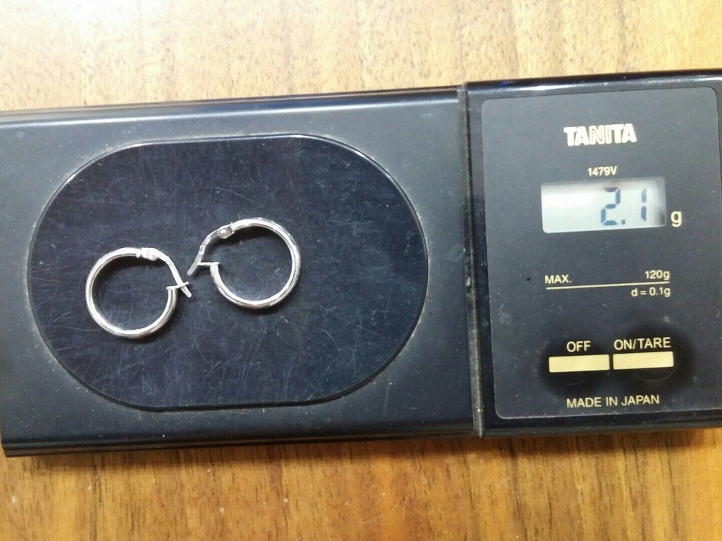 Orecchini a cerchi oro bianco 18 kt  con lavorazione a rilievo e incisioni.