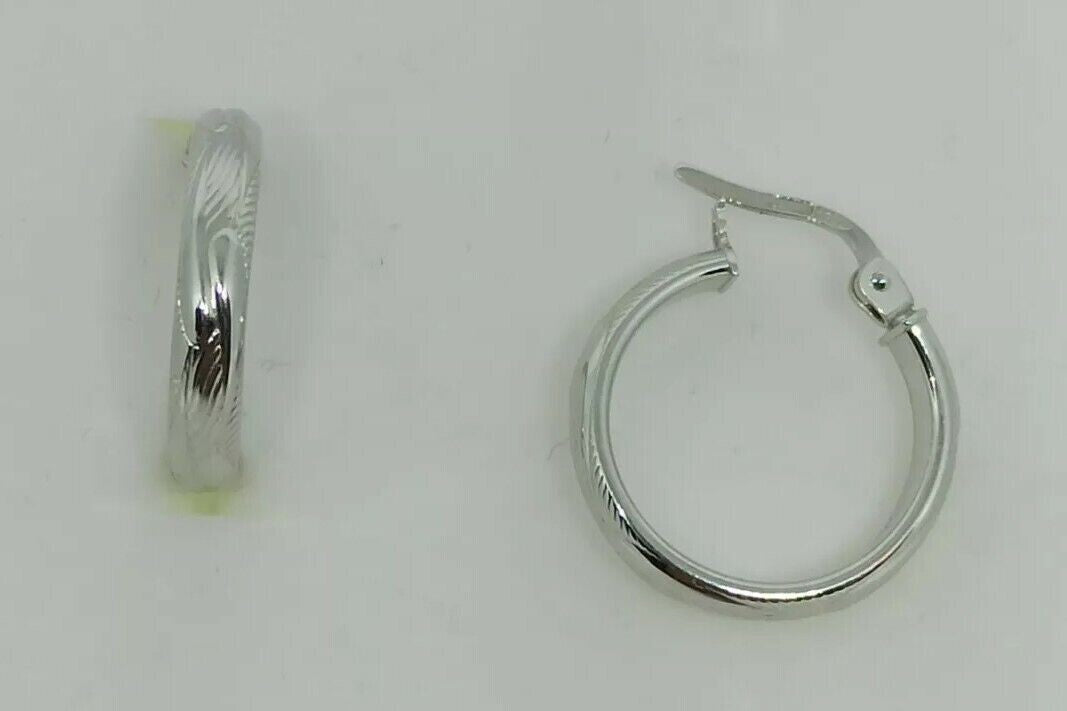 Orecchini a cerchi oro bianco 18 kt  con lavorazione a rilievo e incisioni.