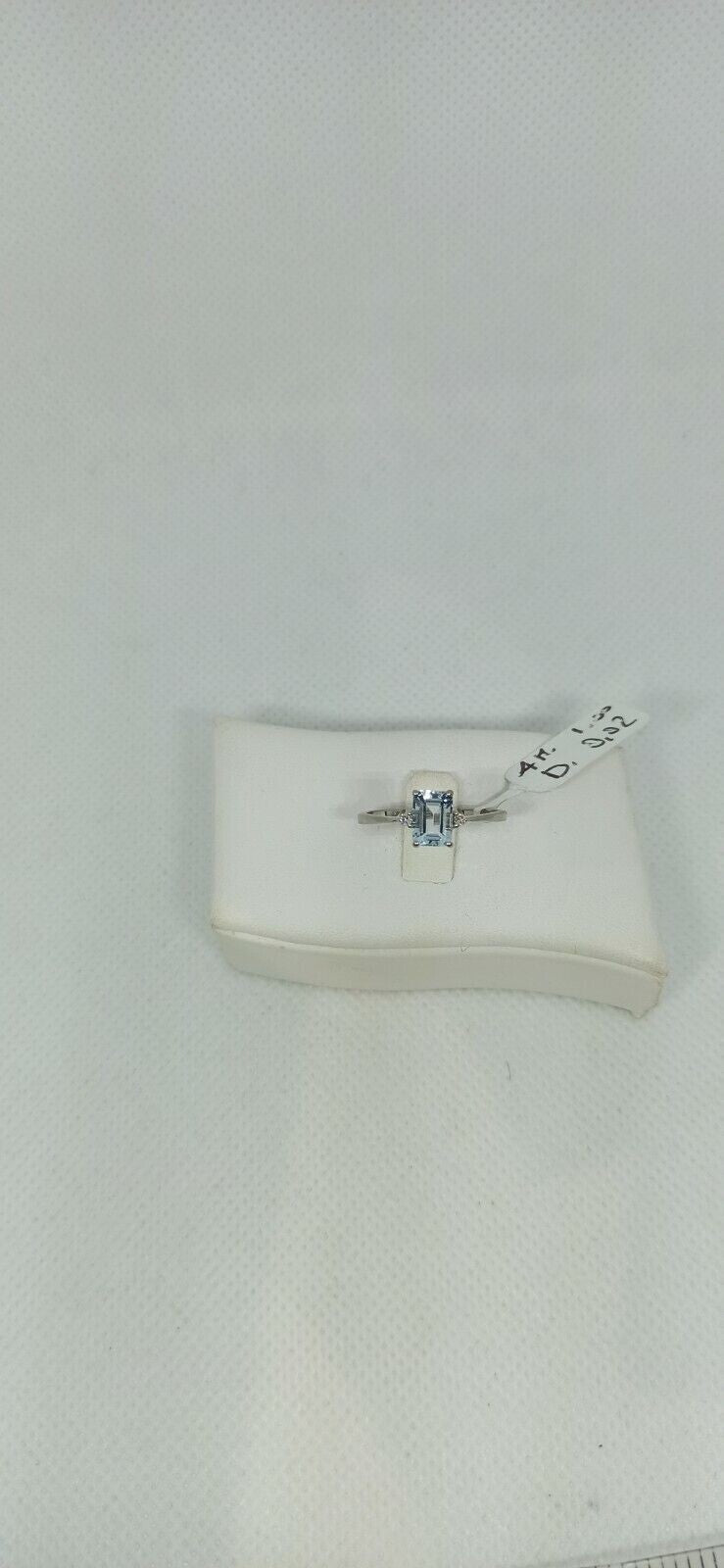 Anello in oro bianco 18 kt con acquamarina rettangolare con due diamanti.