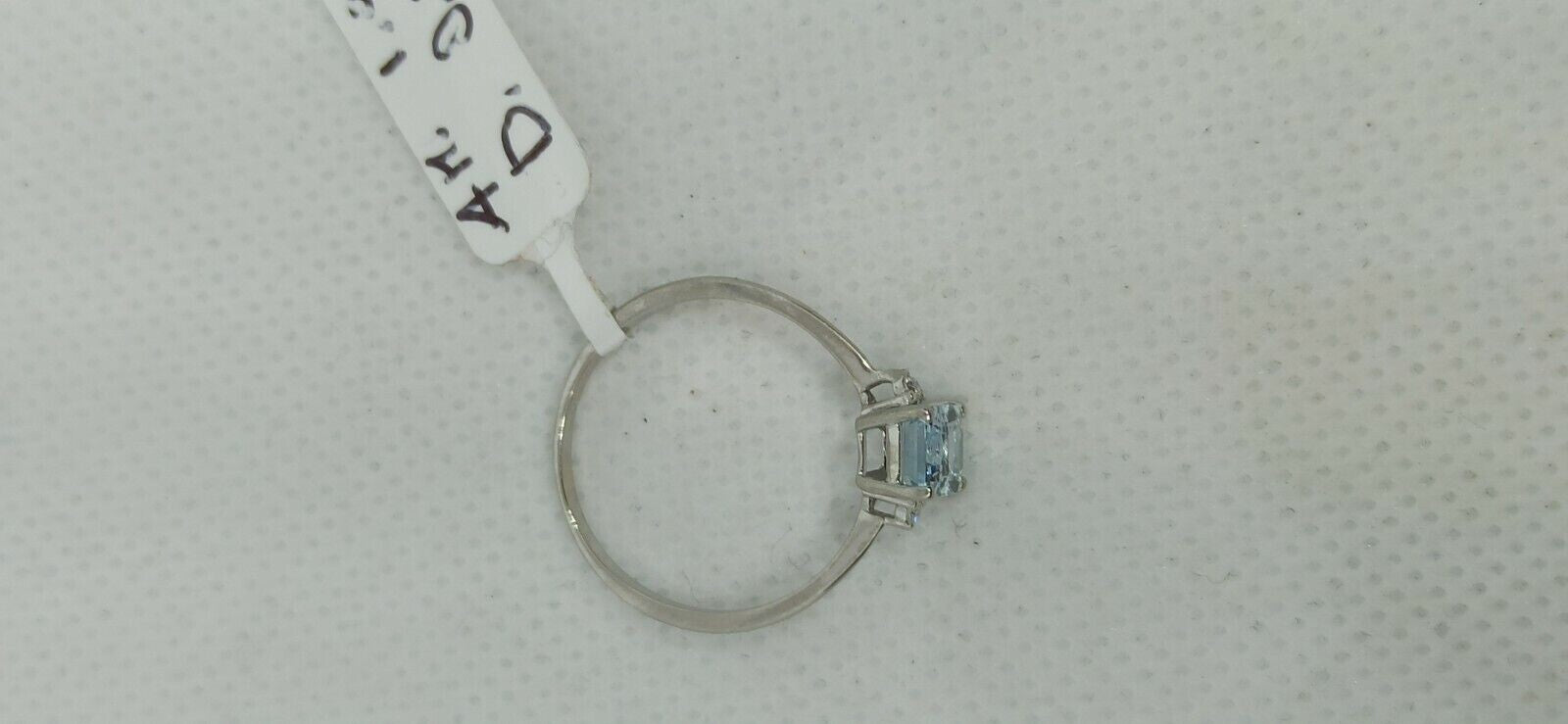 Anello in oro bianco 18 kt con acquamarina rettangolare con due diamanti.