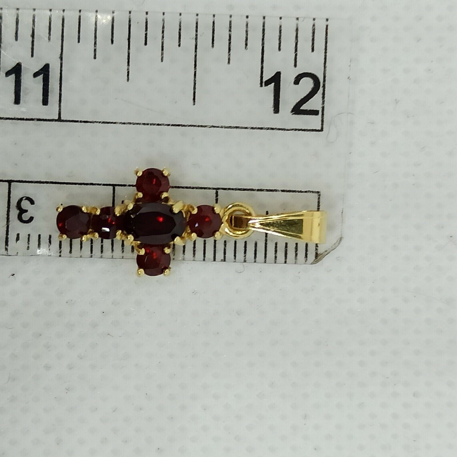 Croce in oro giallo  18 kt pendente con granato.