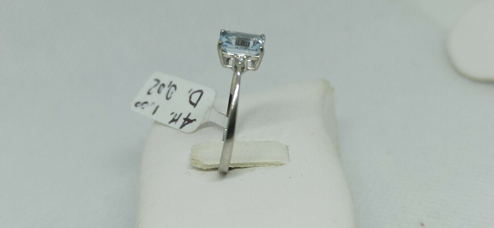 Anello in oro bianco 18 kt con acquamarina rettangolare con due diamanti.