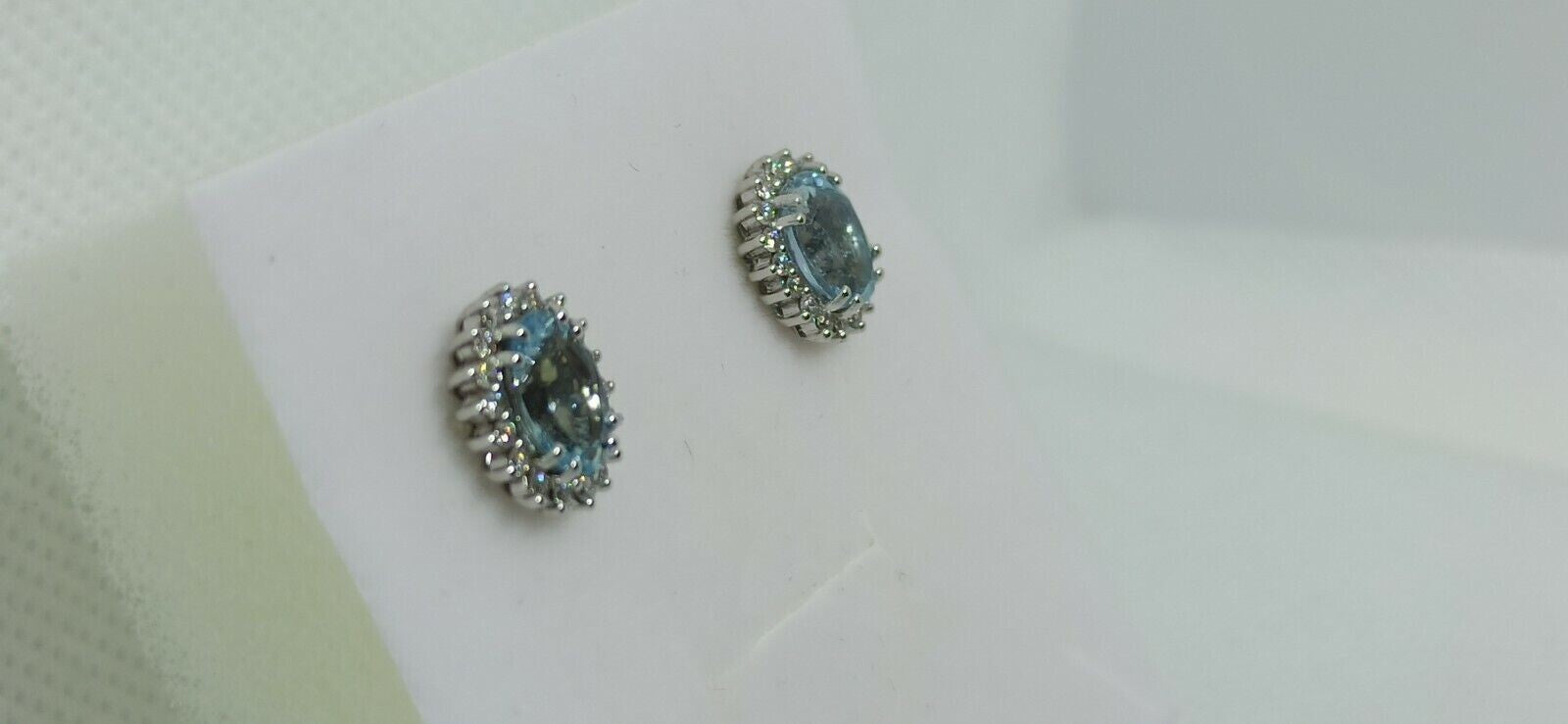 Orecchini in oro bianco 18 kt con acquamarina ovale contornata da diamanti .
