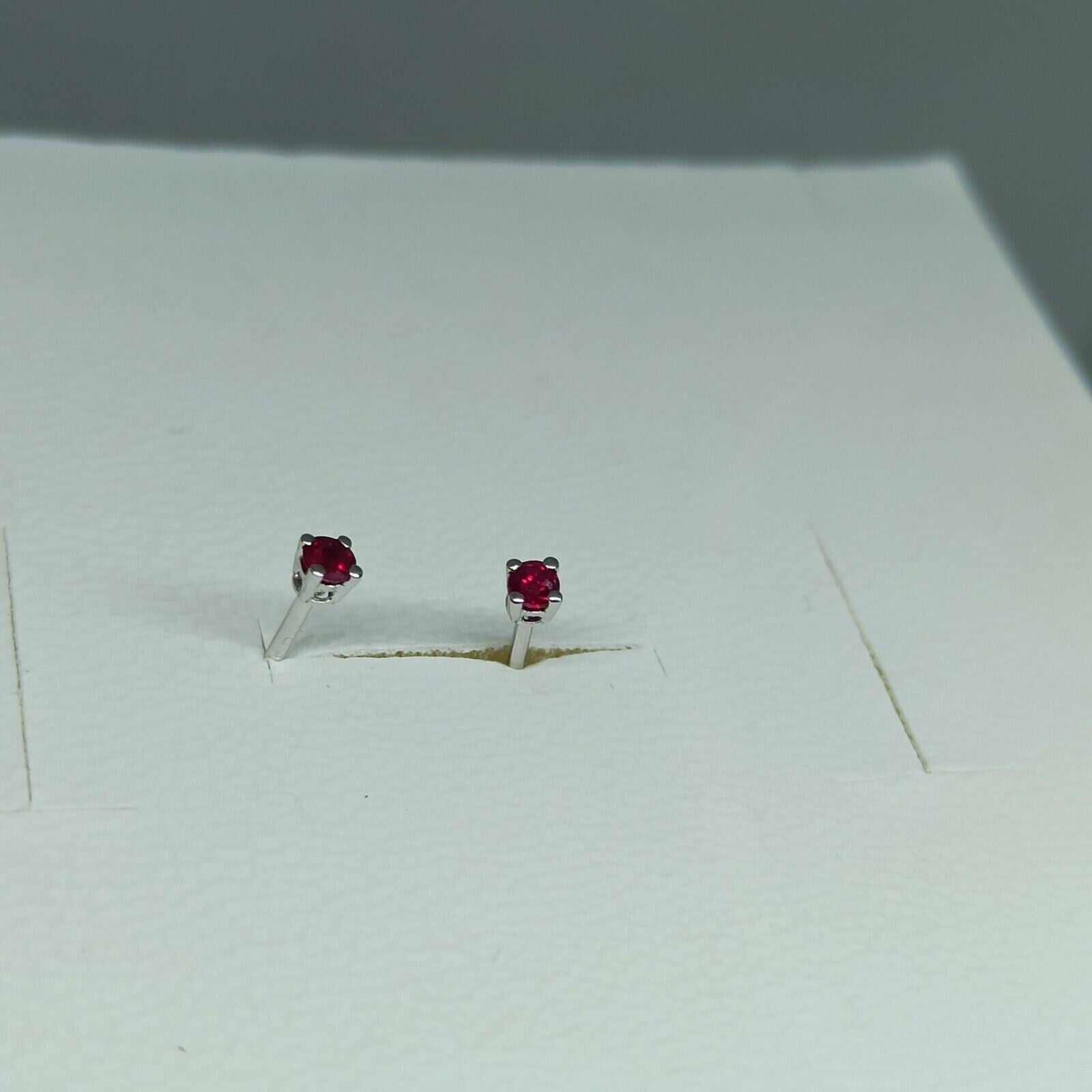 Orecchini punto luce in oro bianco  18 kt  con rubino ct 0,20.