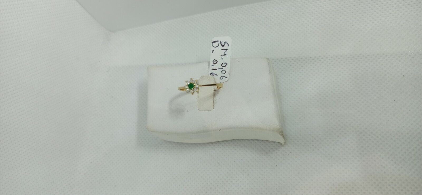 Anello in oro giallo 18 kt con smeraldo tondo e contorno di diamanti.