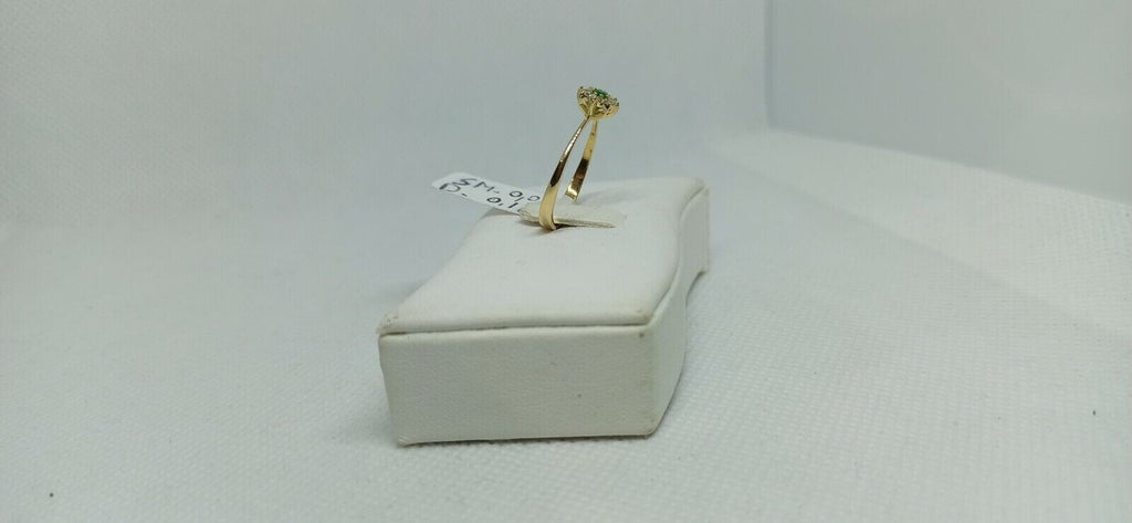 Anello in oro giallo 18 kt con smeraldo tondo e contorno di diamanti.