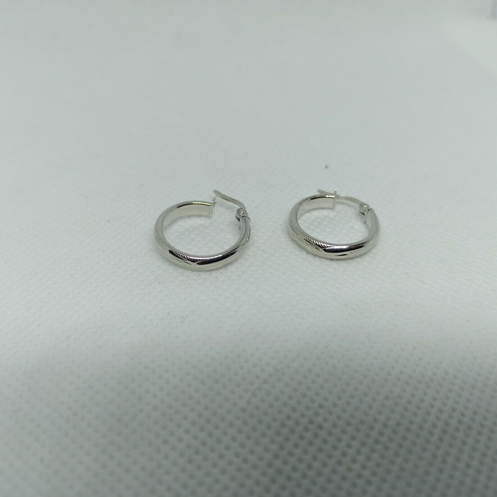 Orecchini a cerchi oro bianco 18 kt  con lavorazione a rilievo e incisioni.