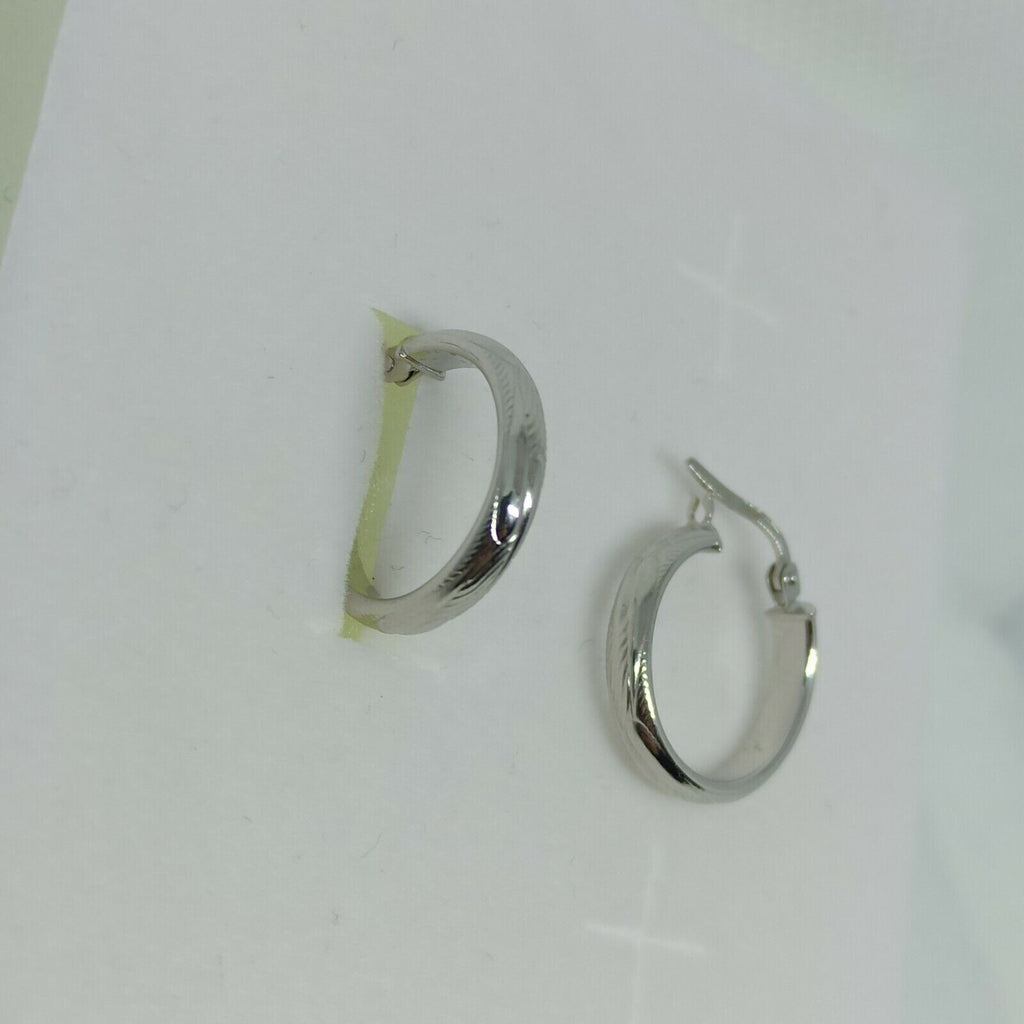 Orecchini a cerchi oro bianco 18 kt  con lavorazione a rilievo e incisioni.